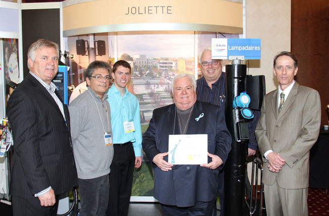 La Ville de Joliette a été lauréate dans la catégorie Transport et voirie grâce à ses lampadaires polyvalents lors du huitième mérite Ovation municipale tenu à Gatineau du 9 au 11 mai. Dans l’ordre habituel, MM. Alain Beaudry et Normand-Guy Lépine, conseillers, Jérémy Champagne, stagiaire à Hydro-Joliette, le maire René Laurin, le conseiller Richard Leduc ainsi que le directeur général, Renald Gravel.