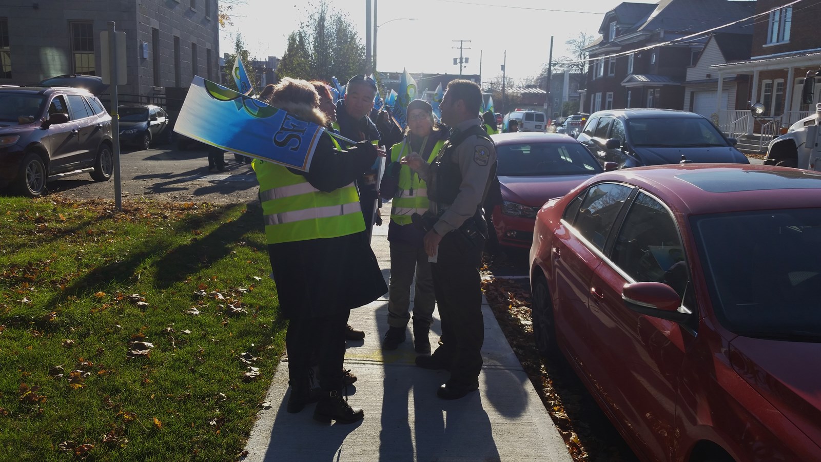 Quelques manifestants discutent avec un policier de la Sûreté du Québec, dont le véhicule suivait le fourgon cellulaire.