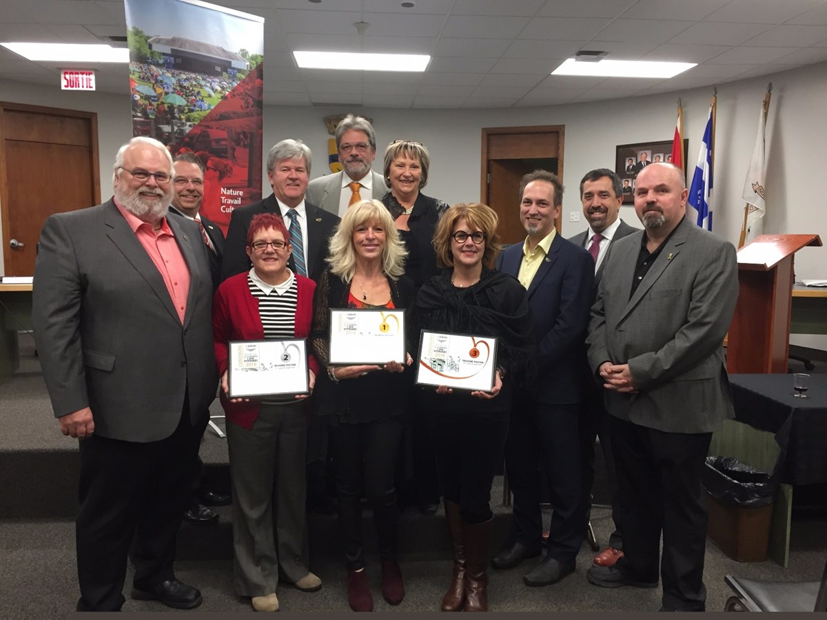 M. Richard Leduc, maire suppléant de Joliette, et les membres du conseil municipal entourent les gagnants de l’édition 2016 du concours Ma ville, mon commerce, ma vitrine!
