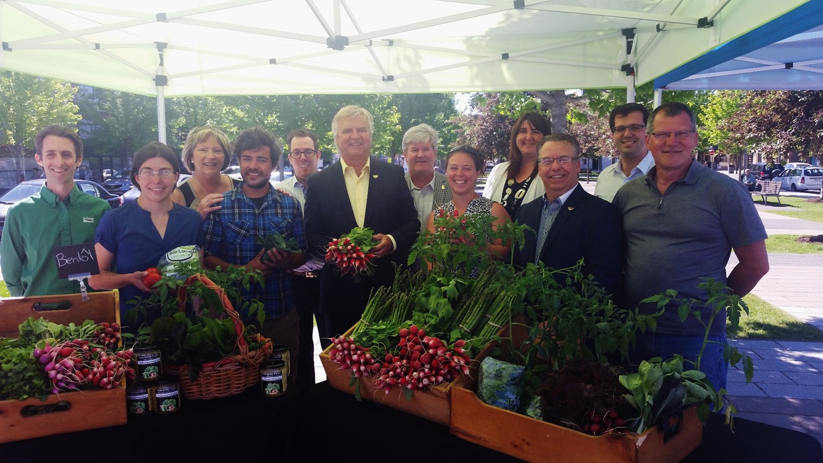 Sur la photo, Alain Beaudry, maire de Joliette (au centre) est en compagnie de quelques producteurs. On retrouve aussi Jacques Leblanc (Coop Profid'or), la conseillère Danielle Landreville, Ludovic Beauregard (président du Marché), David Bélanger (Président de la Société de Développement du Centre-Ville de Joliette), le conseiller Luc Beauséjour, Monique Desrosiers (Caisse Desjardins de Joliette) et le conseiller Patrice Trudel.