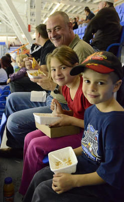 Pierre Morin n'hésite pas à déguster une poutine avec ses enfants Carolann et Alexandre, lui qui est contre l'abolition de la malbouffe dans les arénas. Trois-Rivières le 25 septembre 2011. NICOLAS DUCHARME/L'ÉCHO DE TROIS-RIVIÈRES/AGENCE QMI