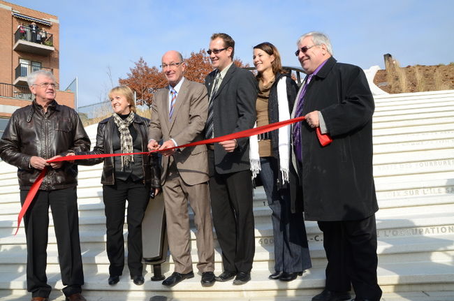 Le maire Yves Lévesque coupe le traditionnel ruban au pied du nouvel escalier monumental, entouré de Michel Veillette, conseiller du district de Pointe-du-Lac, Micheline Courteau, conseillère du district de Sainte-Marthe, Marc-André Godin, coordonnateur à la gestion des programmes et des projets de développement à la Ville de Trois-Rivières, Amélie Germain, architecte paysagiste, et Michel Bronsard, conseiller du district de Saint-Louis-de-France.