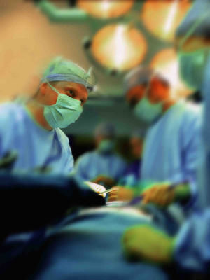 side profile of surgeons performing surgery