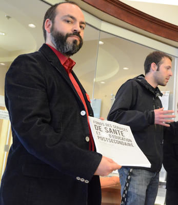 L attaché politique de l AGE UQTR, François Landry, avec le document que les étudiants ont présenté à la députée Danielle Saint-Amand. À l'arrière, le président de l'AGE UQTR, Hugo Mailhot Couture. Trois-Rivières le 12 avril 2012. NICOLAS DUCHARME/L'ÉCHO DE TROIS-RIVIÈRES/AGENCE QMI