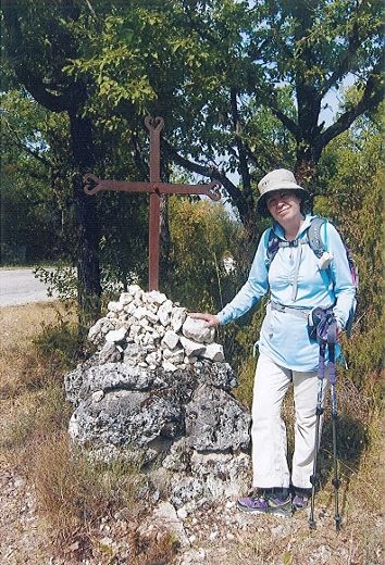 Hélène Dupont dépose une pierre sur une croix de chemin 