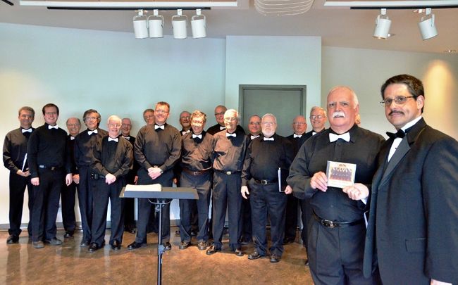 À l’avant-plan, de droite à gauche:Martin Brossard, directeur musical du Chœur des Pèlerins, et Germain Ross, président du conseil d’administration du chœur. Ils posent devant l’ensemble des choristes.