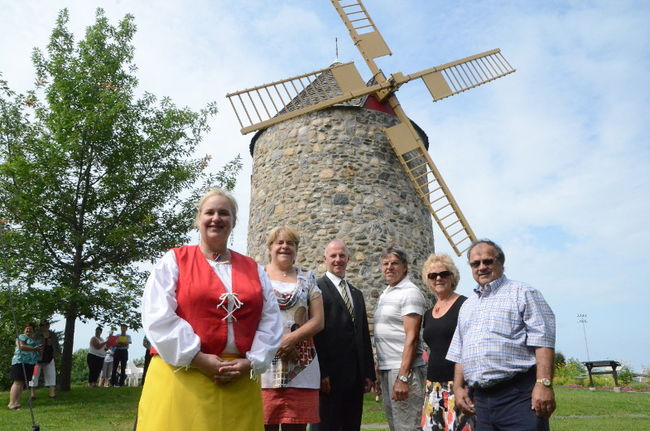 Barbara Dubuc de la Société Acadienne Port-Royal, Gaétane Désilets, mairesse de Bécancour, Simon Lemay, directeur général de la Caisse Desjardins Godefroy, Simon Cormier, représentant de la famille honorée, Ghislaine Beaudry, membre du comité du Festicadie, René Morrissette, président d’honneur du Festicadie devant Le Vieux Moulin de Saint-Grégoire.