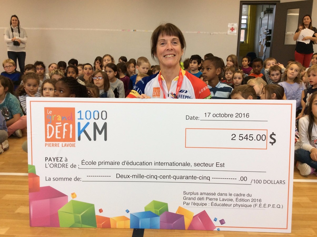Une enseignante d’éducation physique heureuse de remettre deux chèques de 2 545 $ chacun aux deux écoles primaires d’éducation internationale de Trois-Rivières