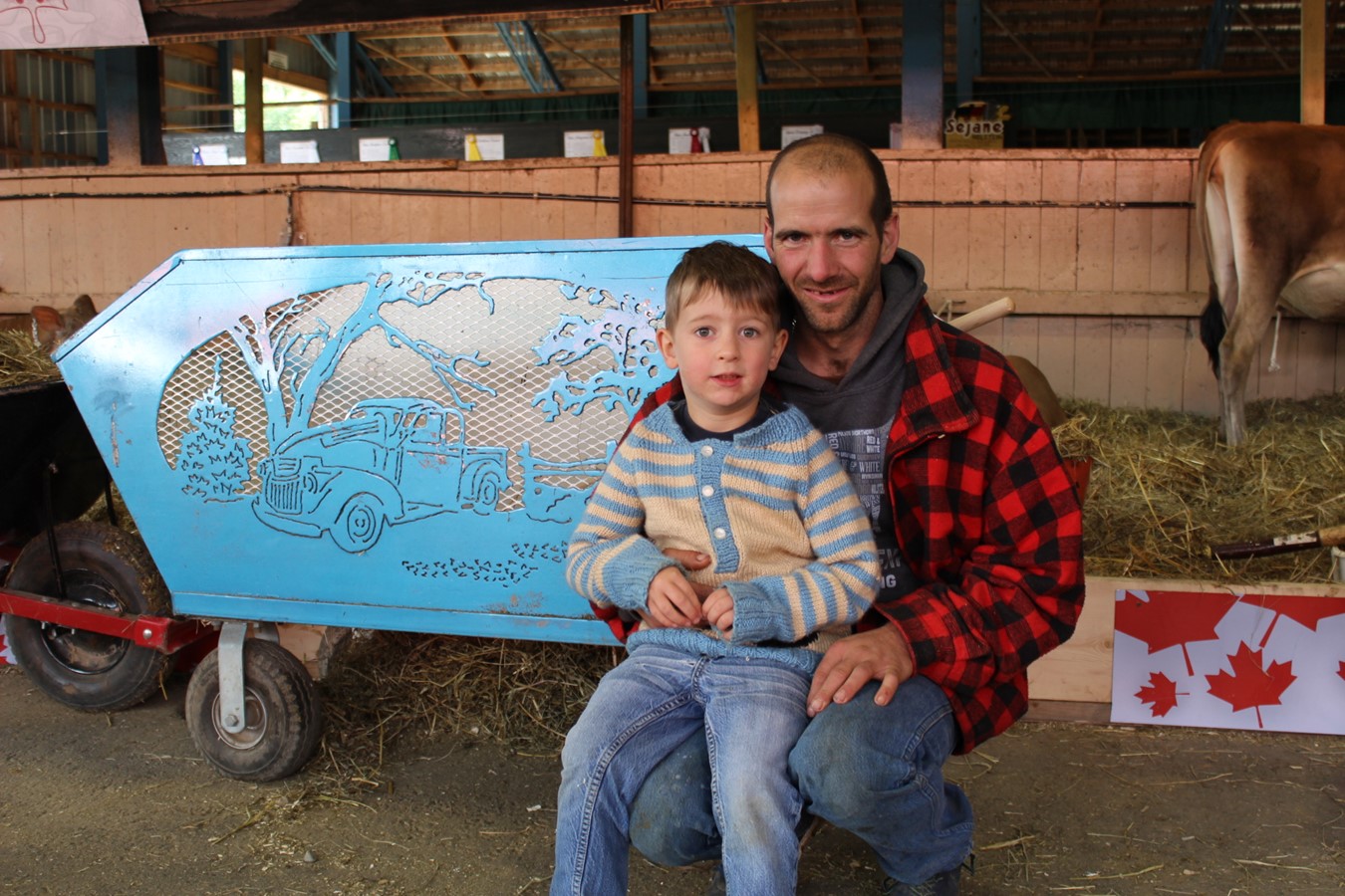 Danny Perkins et son neveu à proximité du chariot à foin qui a été sa première réalisation.