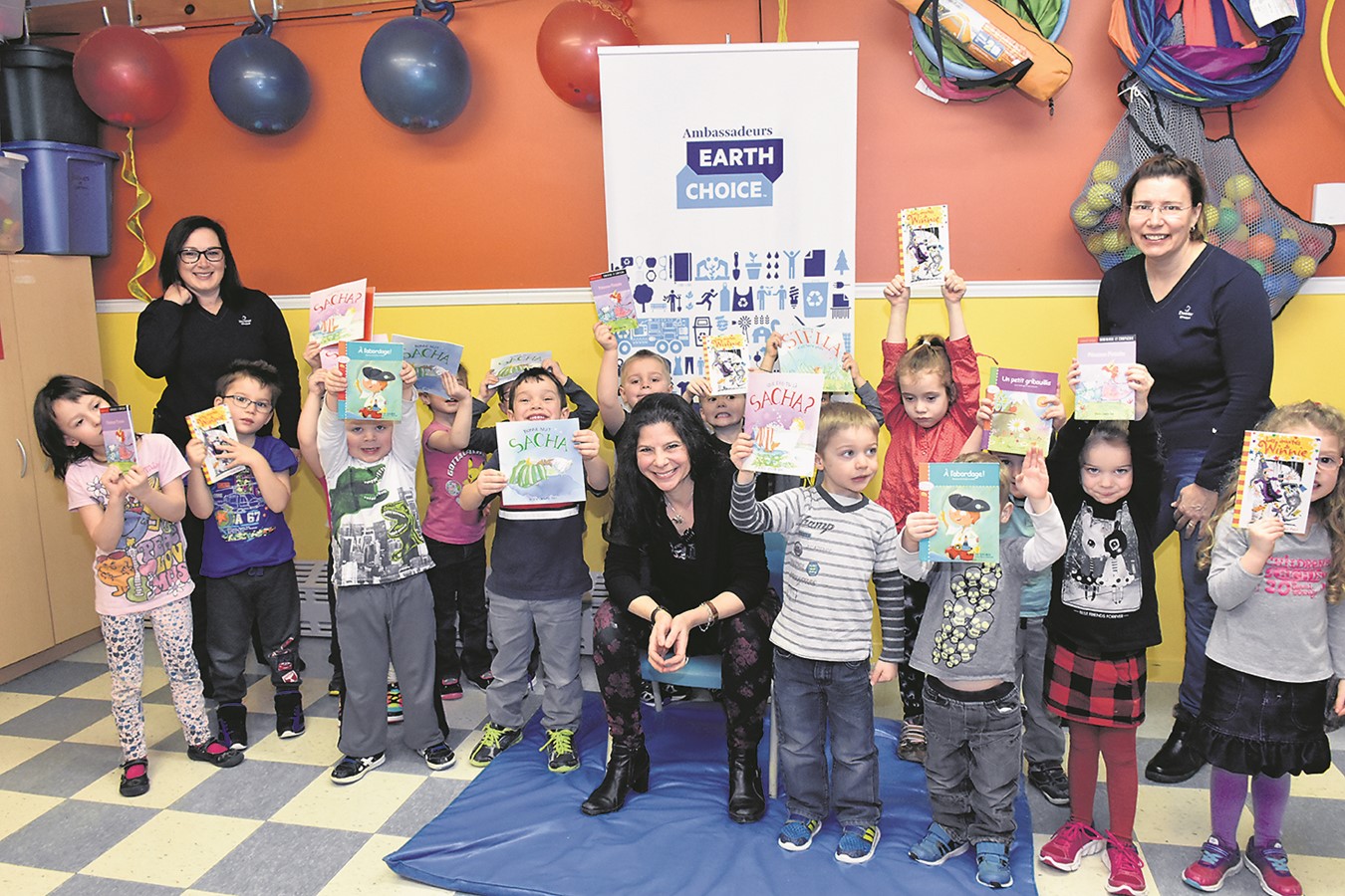 Des jeunes tous heureux de leurs nouveaux livres. Aux deux extrémités : Providence Cloutier, conseillère principale aux communications à l’usine Domtar de Windsor, et l’enseignante Isabelle Richmond. Au centre : Isabelle Gosselin, conteuse, musicienne, auteure, comédienne et… conteuse!