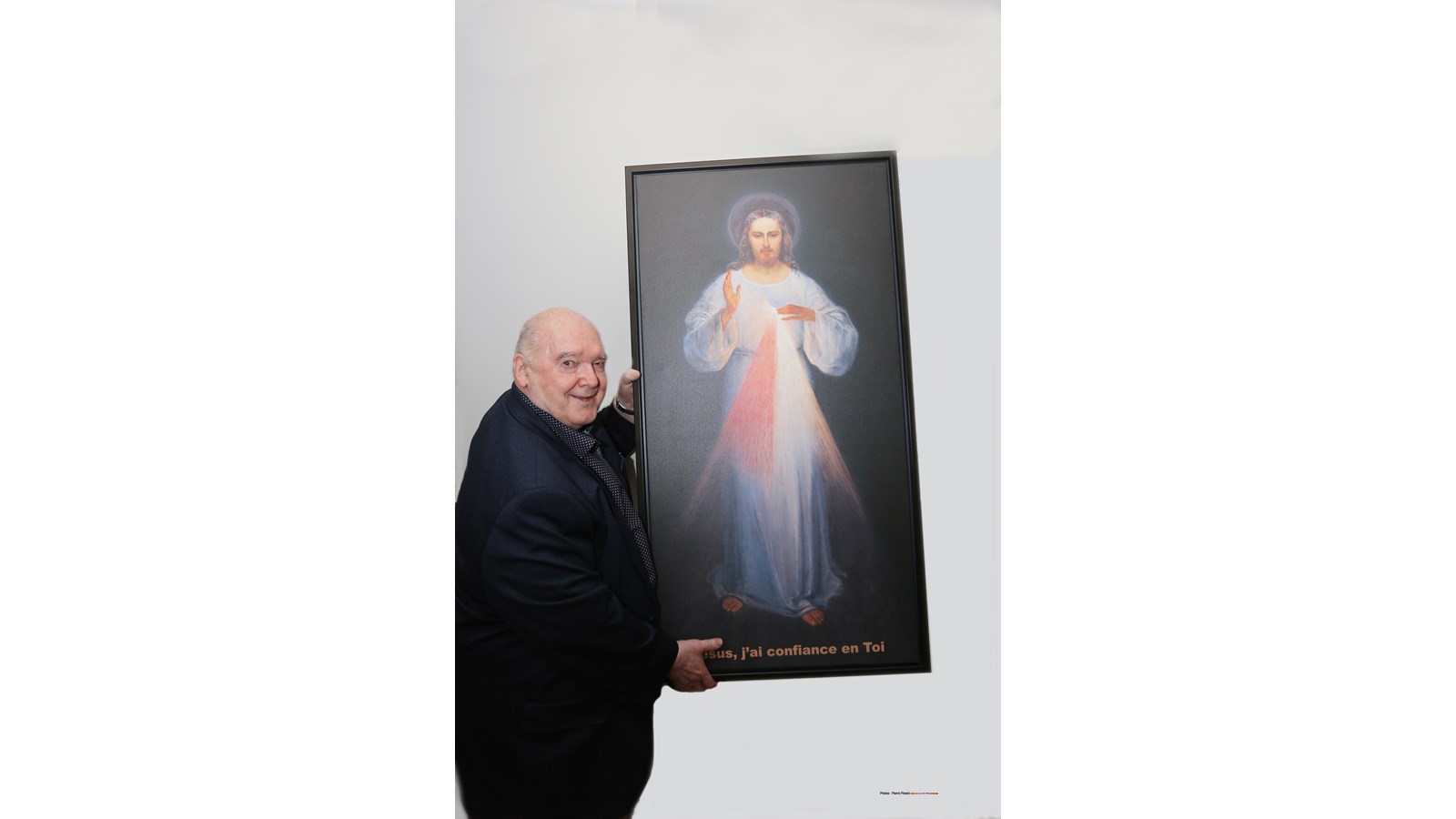 L’abbé Guy Giroux avec l’image installée dans la chapelle du Château Bel Âge de Windsor.