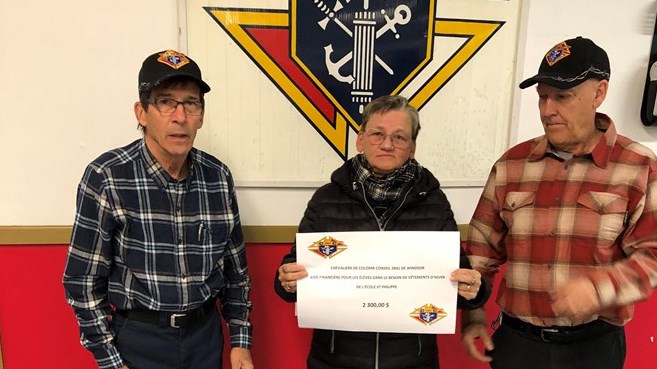 Gérald Saint-Laurent et Marc Morin, des Chevaliers de Colomb de Windsor, ont remis 2300 $ à Chantal Corriveau, surveillante-éducatrice au service de garde de l’école Saint-Philippe.
