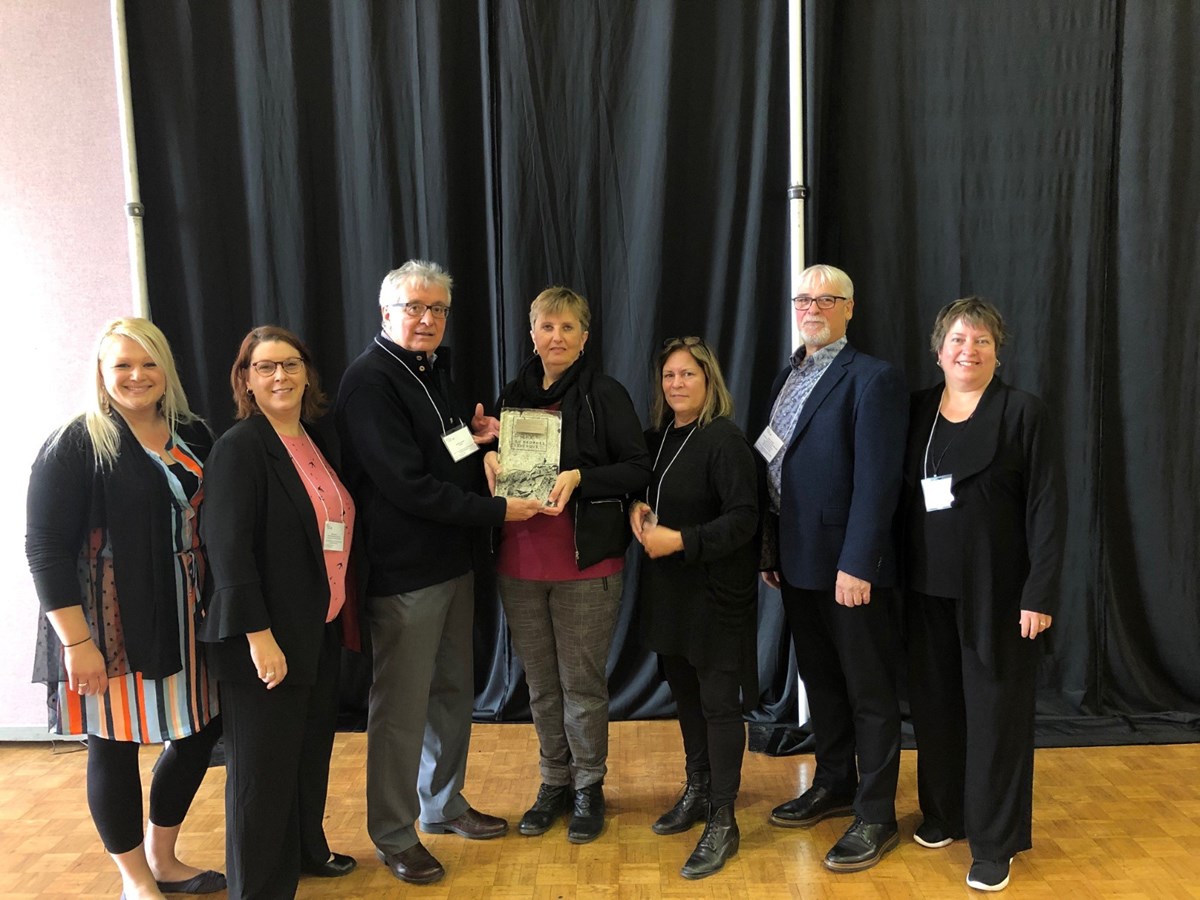 Troisième à partir de la gauche, Dr Georges Levesque, hémato-oncologue, remet le prix à l’équipe de l’Association du cancer de l’Est du Québec représentée par Janie Malenfant, adjointe administrative secteur services, Nancy Renaud, directrice des services sur le territoire, Lise Fréchette, directrice générale, Nathalie Turgeon, coordonnatrice de la programmation et du développement des activités psychosociales, Nelson Charette, ex-directeur général et Josée Fortin, directrice du financement.