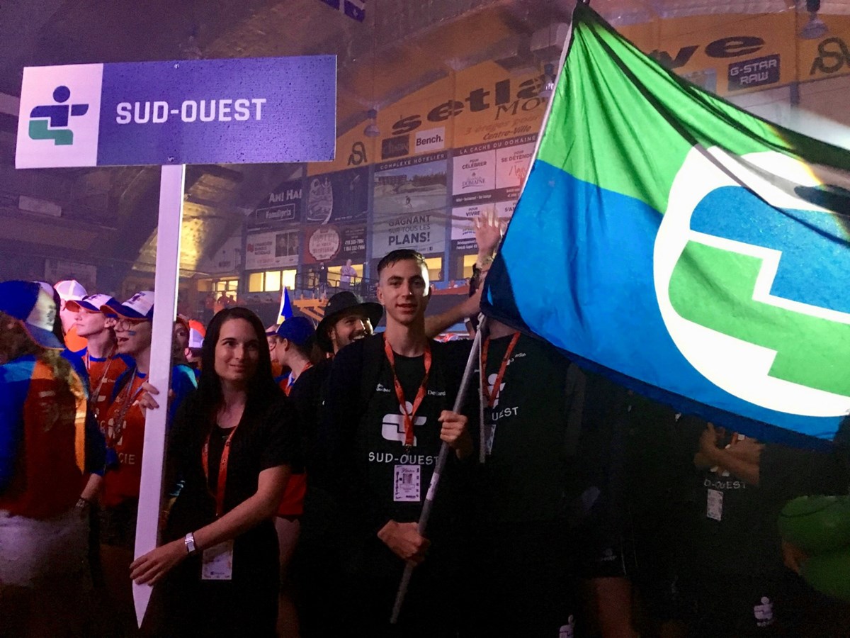 Adam Domanski, le porte-drapeau du Sud-Ouest, suivi de la délégation, à leur entrée dans le Centre Mario-Gosselin