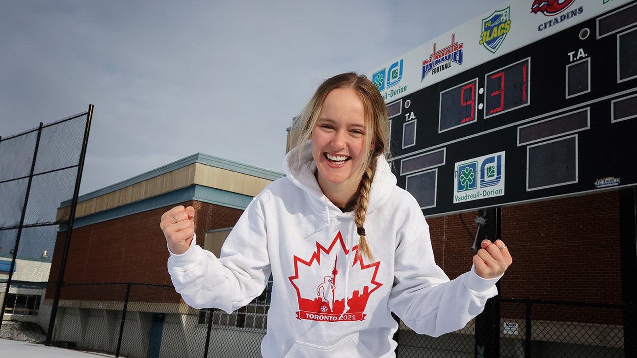 Gabrielle Côté, les poings en l'air, aborant son gilet du championnat canadien collégial, sera bientôt en route vers New York.