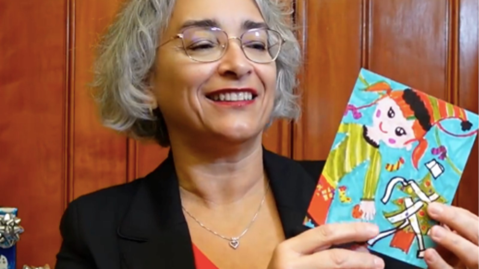 Claude DeBellefeuille montre la carte sur laquelle figure le dessin de la gagnant Évelyne Ménard 