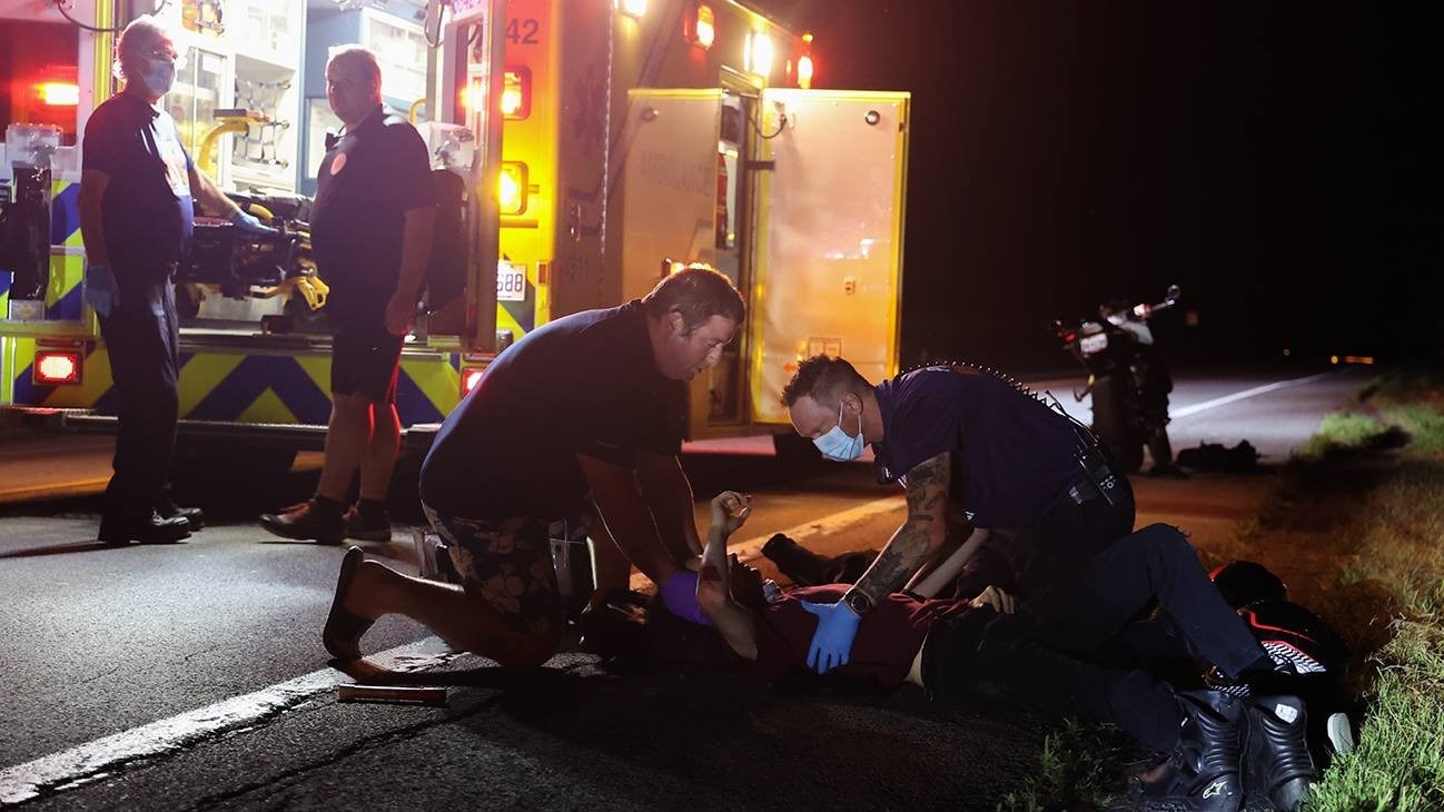 Deux pompiers prêtent assistance à des motocyclistes entrés en collision près de leur résidence