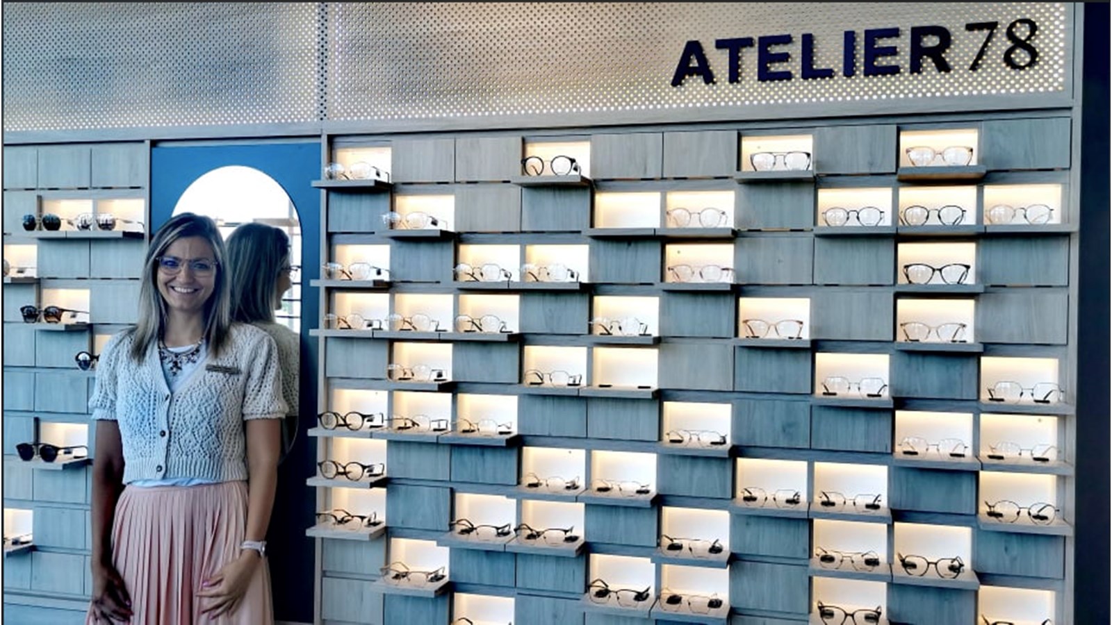 La directrice de succursale et opticienne associée Marine Pignot pose devant la collection maison de la Lunetterie Doyle baptisée Atelier 78