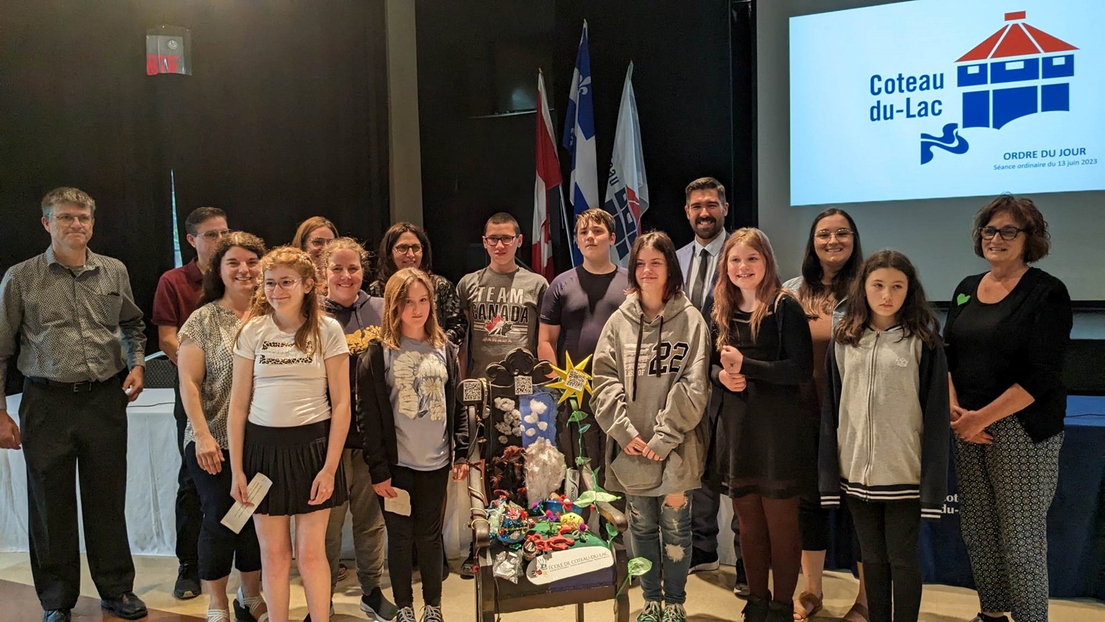 Les jeunes artistes qui ont conçu la Chaise ont pris la pose avec les élus et leur enseignante Mylène de même que Mme Robichaud de l'organisme Mères au front