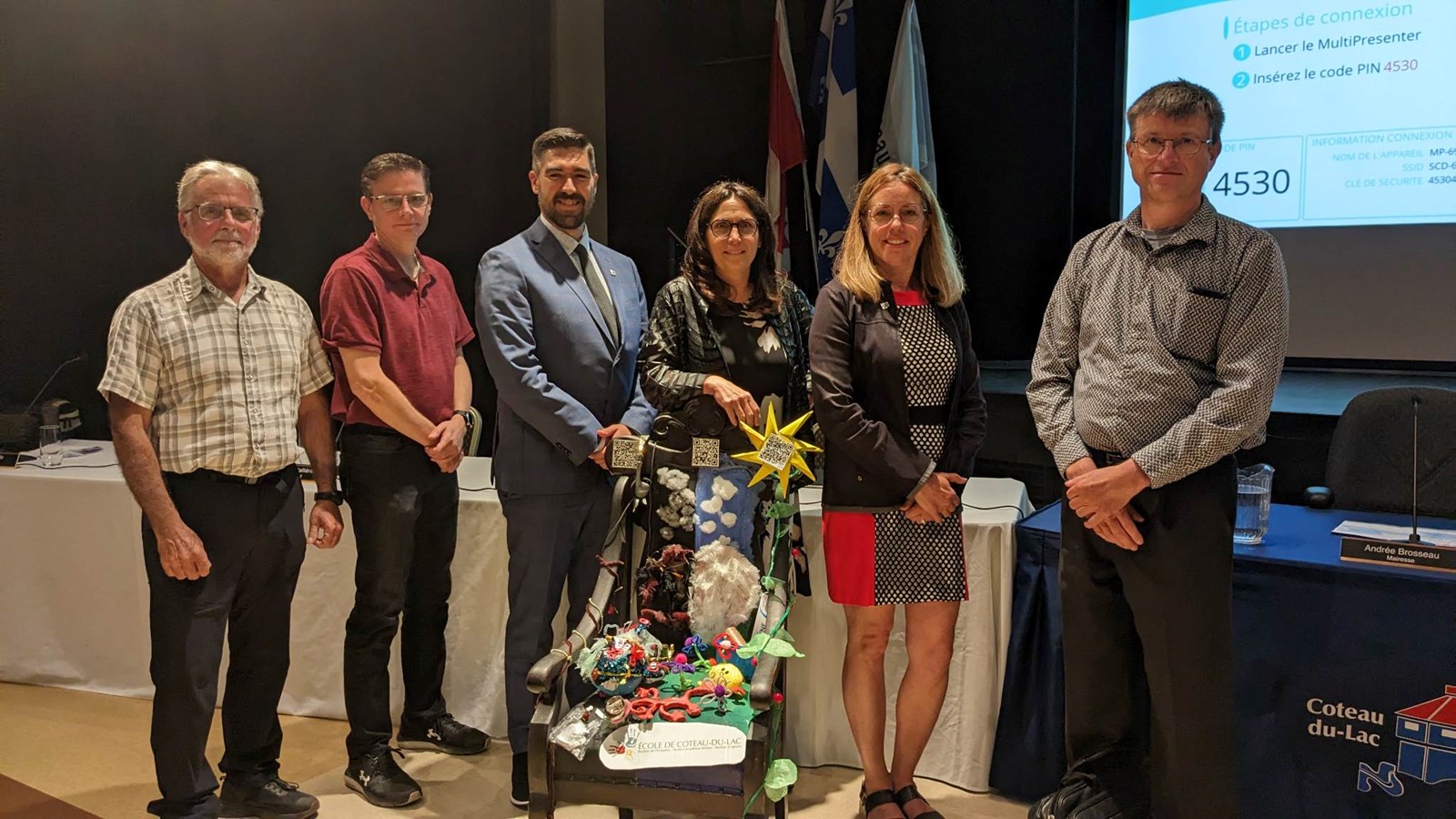 Le conseil municipal prend la pose avec la Chaise des générations réalisée par quatre élèves de l'école de Coteau-du-Lac. La conseillère du district 5, Christine Arsenault, était absente.
