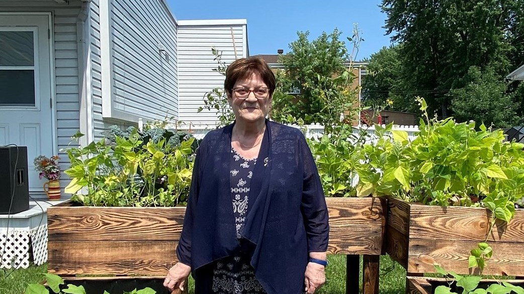Mme Hélène Griffiths prend la pose devant le jardin qui porte son nom