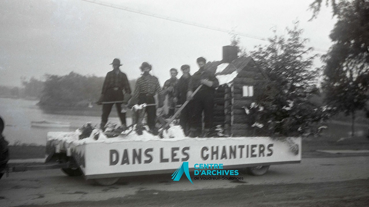 Char allégorique ‘’Dans les chantiers’’, de Quinchien. Louis Meloche, Joseph Bradley, Claude Rousseau, Jules Rousseau et Rhéan Bradley. Le conducteur est Paul-Emile Meloche, 1952.