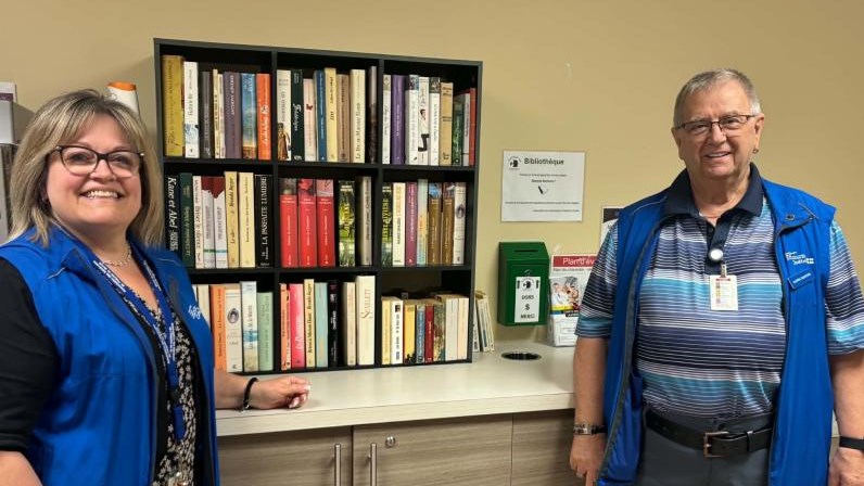 Michelle Bigras et Daniel Marcuri, les bénévoles responsables de ce projet prennent la pose devant la nouvelle bibliothèque
