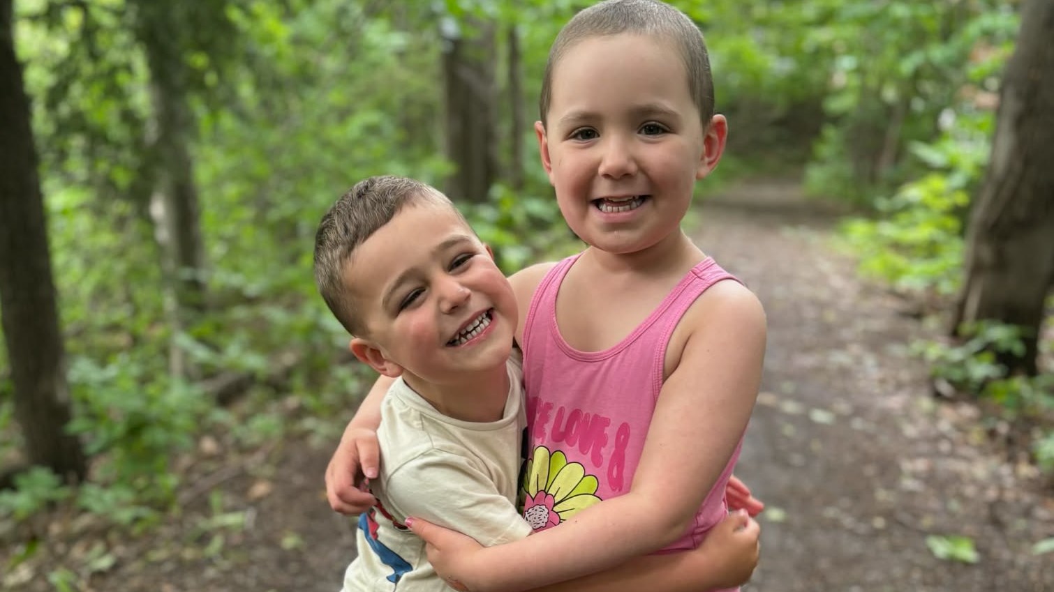 La petite Chiara profite, tout sourire, de l'été qui s'offre à elle en jouant dehors avec son petit frère