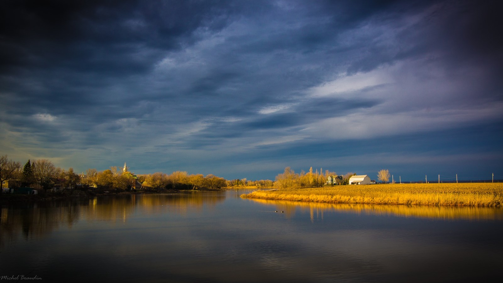 Photo gagnante – Grand Prix Promutuel Assurance Vallée du St-Laurent (bourse de 500 $) – La photo de M. Michel Beaudin de Sainte-Martine intitulée « Lumière d’un samedi matin » illustre un paysage d’automne rural d’où se dégage une atmosphère paisible et calme aux abords de la rivière Châteauguay à Sainte-Martine.