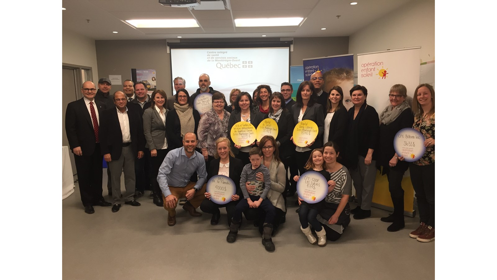 Les récipiendaires des octrois et les partenaires d’Opération Enfant Soleil entourant Caleb McConkey, Enfant Soleil de la Montérégie accompagnés des porte-paroles d’Opération Enfant Soleil lors de la conférence de presse à Vaudreuil-Dorion.