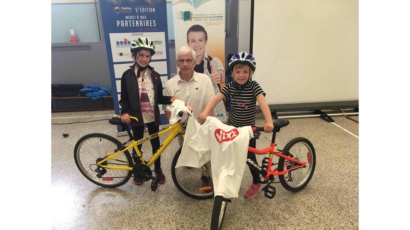 Le président d'honneur prend la pose avec deux jeunes participantes de l'école Saint-Joseph Artisan au Triathlon scolaire du 12 juin prochain. 