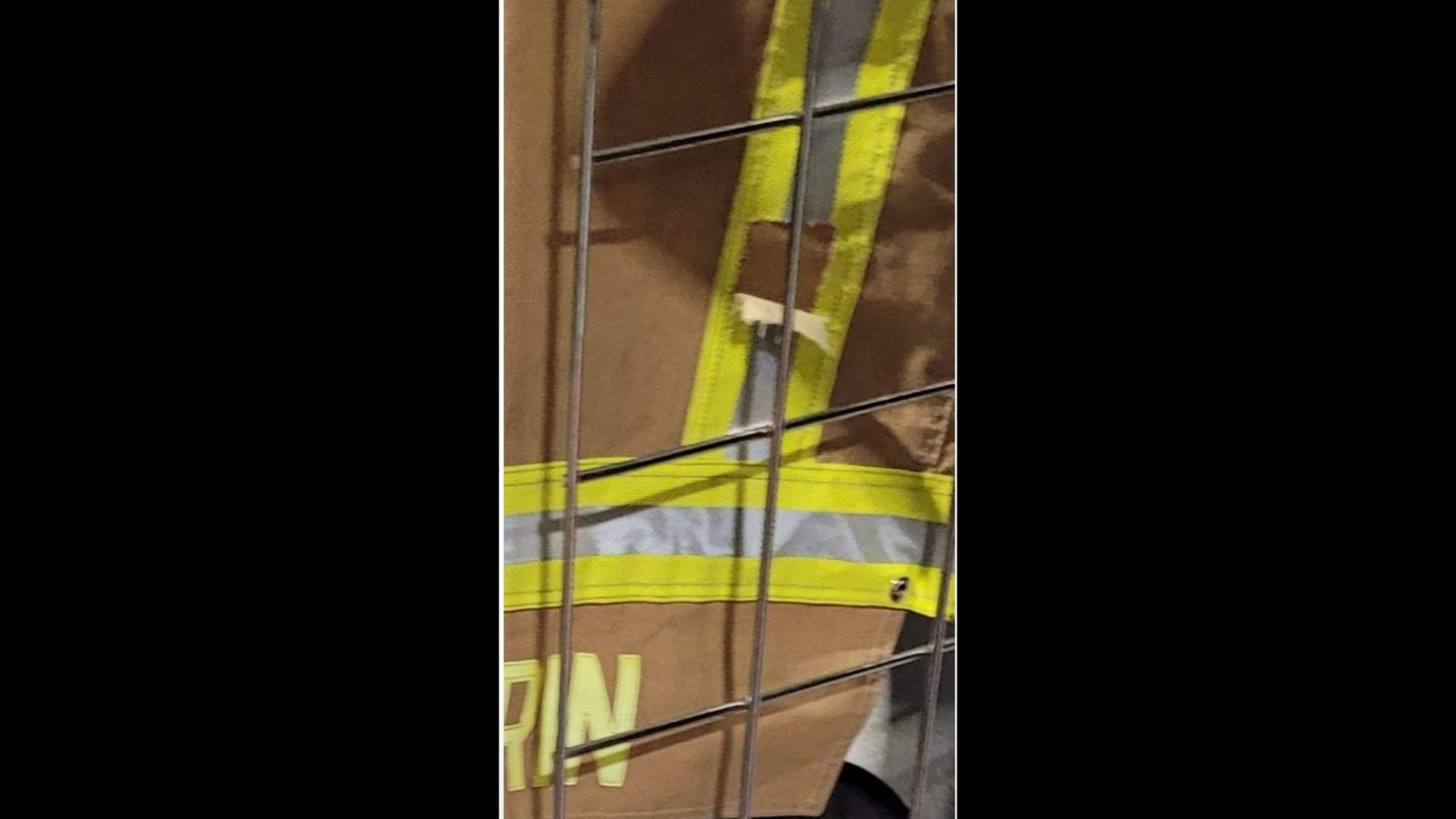 Il faut regarder attentivement pour voir la bande fluorescente sur un habit de combat d'un pompier qui aurait été déchirée dans un acte de vandalisme.
