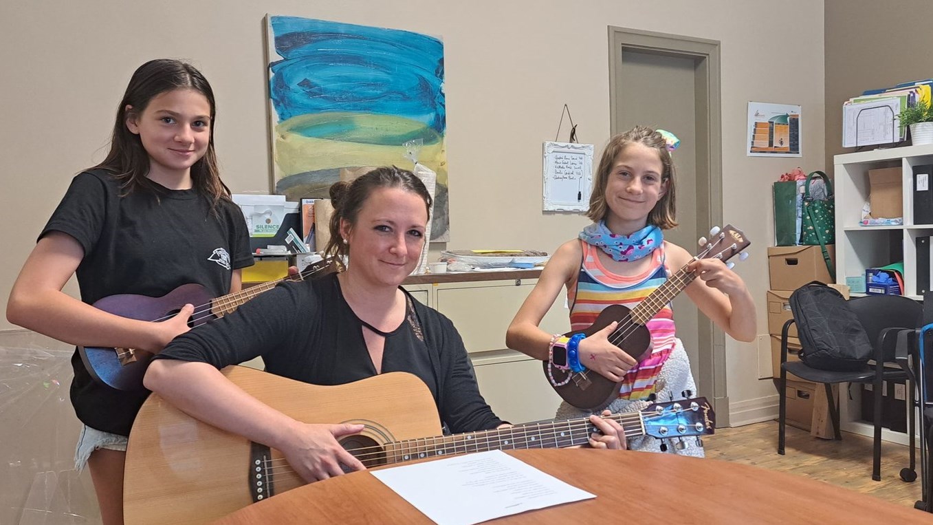 L'enseignante de musique Véronique Plamondon prend la pose avec deux jeunes participantes du projet: Leonie et Catherine. 