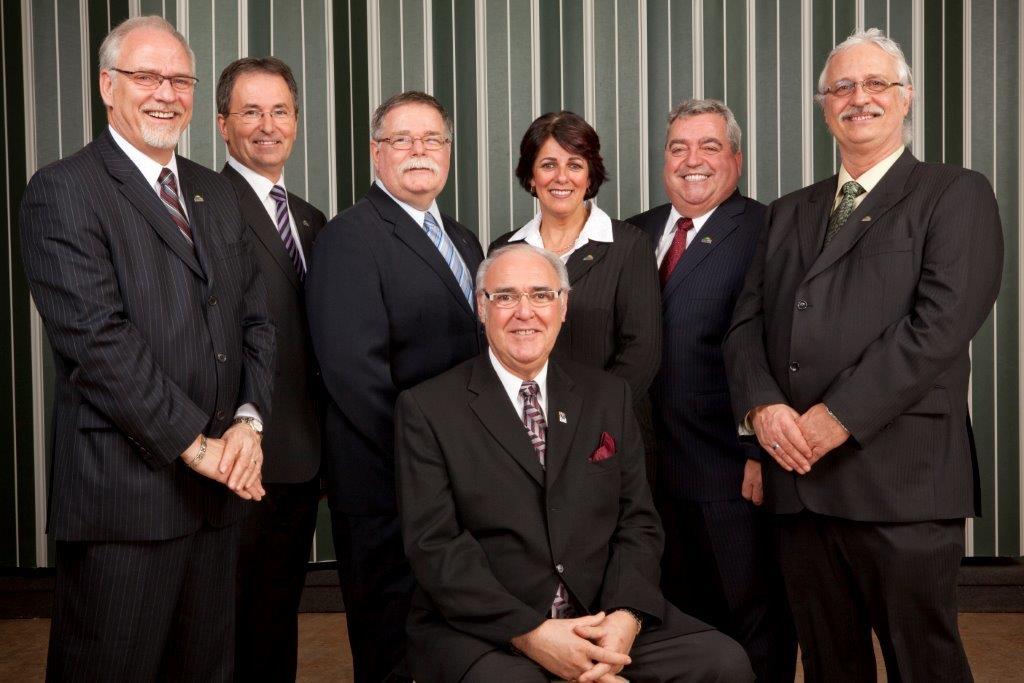 Les candidats indépendants Claude Lebeuf, André Robert, Michel Marleau, Danielle Meunier, Normand Angers et Pierre Wilson entourent le candidat à la mairie et maire actuel de McMasterville, Gilles Plante.