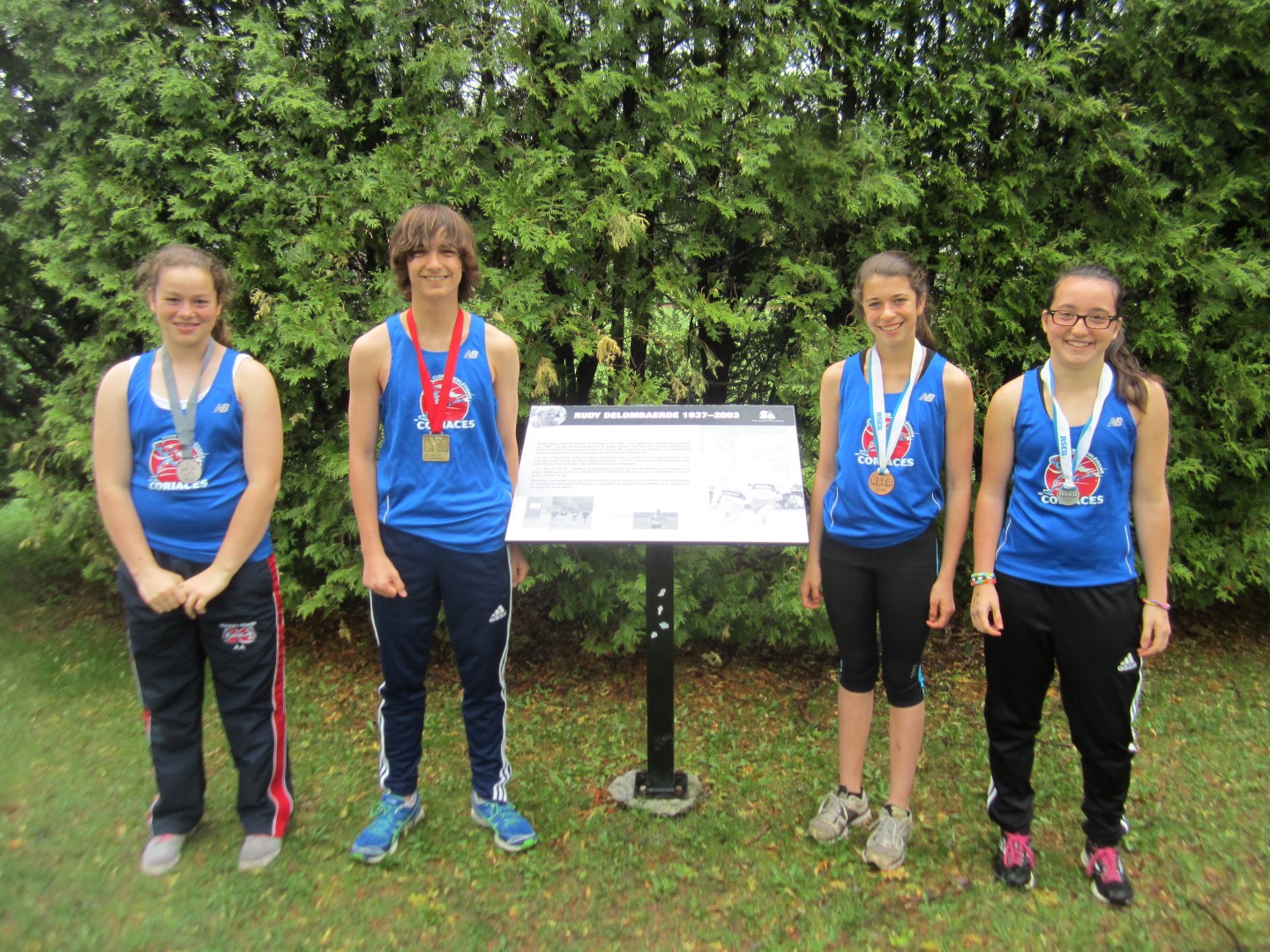 Fondés en 1975, les Coriaces forment l'un des plus vieux clubs d'athlétisme de la province. Les membres posent devant la plaque du fondateur, Rudy Delombarde, au parc Champlain de Mont-Saint-Hilaire.