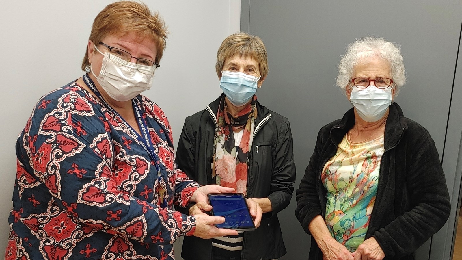 Germaine Deschênes (au centre) et Joëlle Bisson de Courval (à droite) reçoivent une tablette des mains d’Anne Choquet, coordonnatrice des loisirs et événements à la  FADOQ Région Rive-Sud-Suroît.