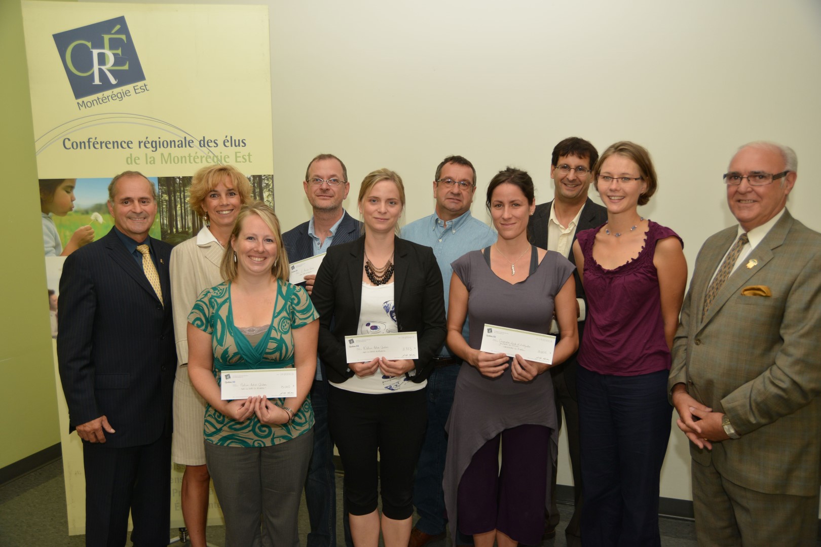 De gauche à droite : Arthur Fauteux, président de la CRÉ Montérégie Est, Nathalie Ward, directrice générale de la CRÉ Montérégie Est, Joanie Beaulieu, chargée de projets pour Nature Action Québec, Stéphane Villeneuve, directeur général d'Arrière Scène, Jacinthe Letendre, chargée de projets pour Nature Action Québec, Denis St-Martin, de la Société historique Pierre-De Saurel, Stéphanie Verriest et Sophie Brulé artistes professionnelles à la Corporation Aide et Intégration jeunesse au travail de la Vallée-du-Richelieu, Pascal Bigras, directeur général de Nature Action Québec, et Gilles Plante, préfet de la MRC de la Vallée-du-Richelieu.