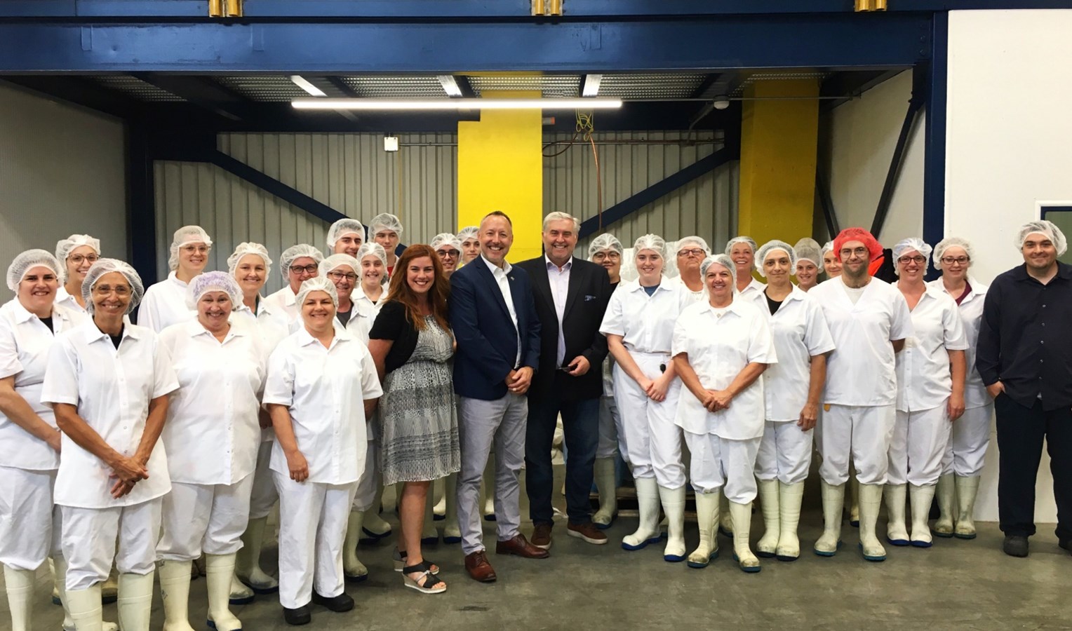e député de Richelieu, M. Jean-Bernard Émond et le président de la Fromagerie Polyethnique Le Bédouin, M. Jean-Pierre Salvas, entourés des employés de l’entreprise.