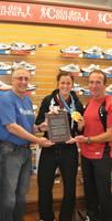 Charline Labonté exhibe fièrement sa médaille d or avec fierté alors qu elle a reçu sa plaque commémorative des mains de John Stanton et de Robert Mailloux, gérant régional du Coin des Coureurs.