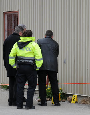 Les enquêteurs de la Régie intermunicipale de police Thérèse-De Blainville observent les ossements qu'ils ont sortis de l'entrepôt désaffecté du boulevard Labelle.
