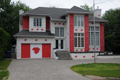 La maison du 205 Boulevard de Gaulle affiche les couleurs rouges du drapeau canadien.