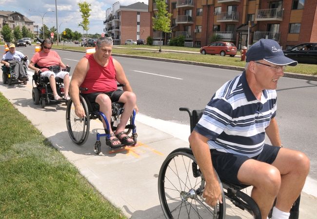 Le conseiller municipal de Sainte-Thérèse, Vincent Arseneau (en avant) a dû trimer dur afin de parcourir les rues de Sainte-Thérèse en fauteuil roulant.