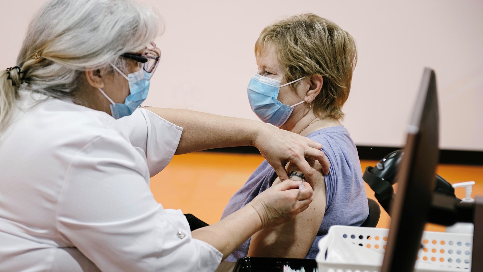 Madame Lucille Cyr reçoit sa première dose du vaccin contre la COVID-19, accompagnée de l’injectrice Carole Oundjian du CISSS des Laurentides
