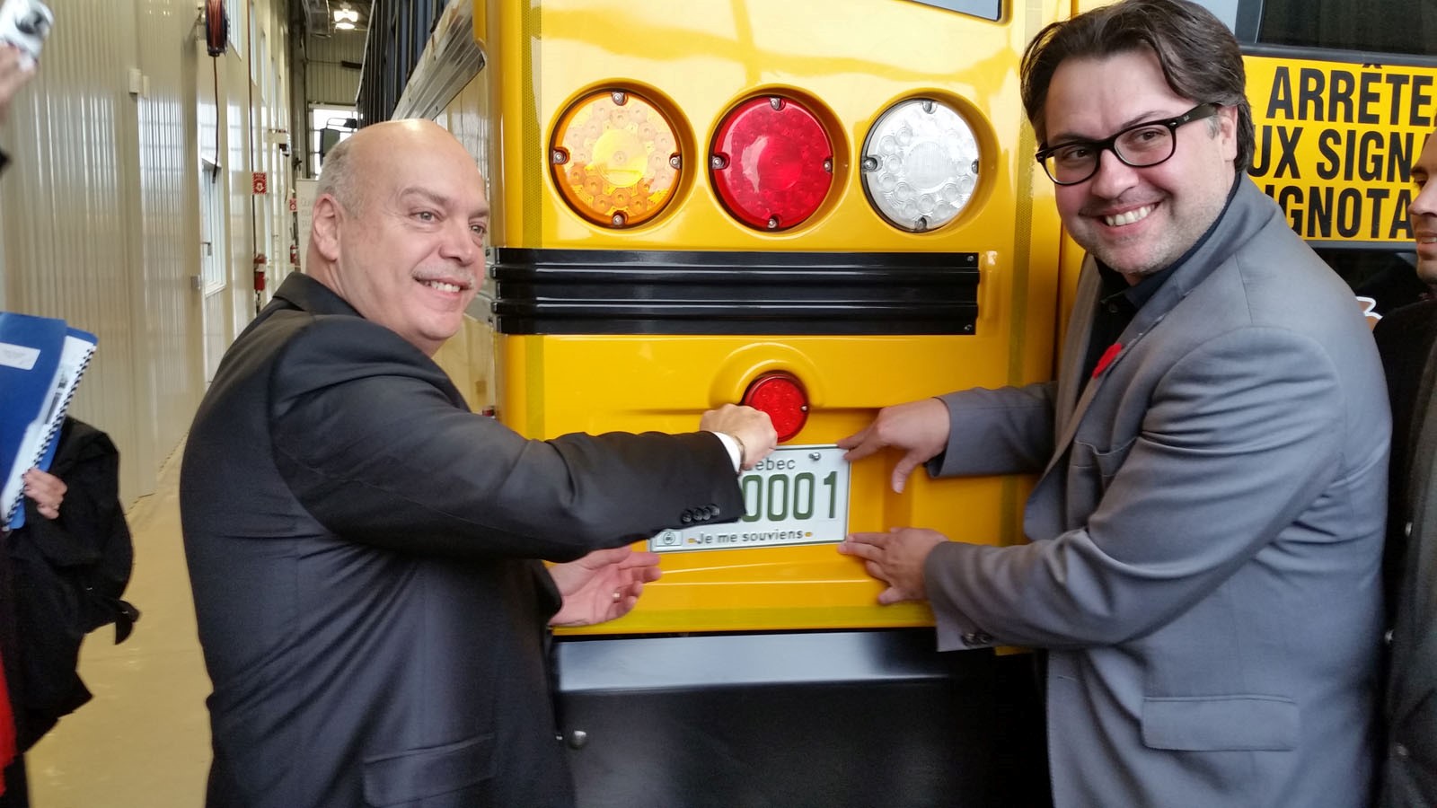 Les ministres Robert Poëti et David Heurtel installent la plaque d'immatriculation sur le véhicule.