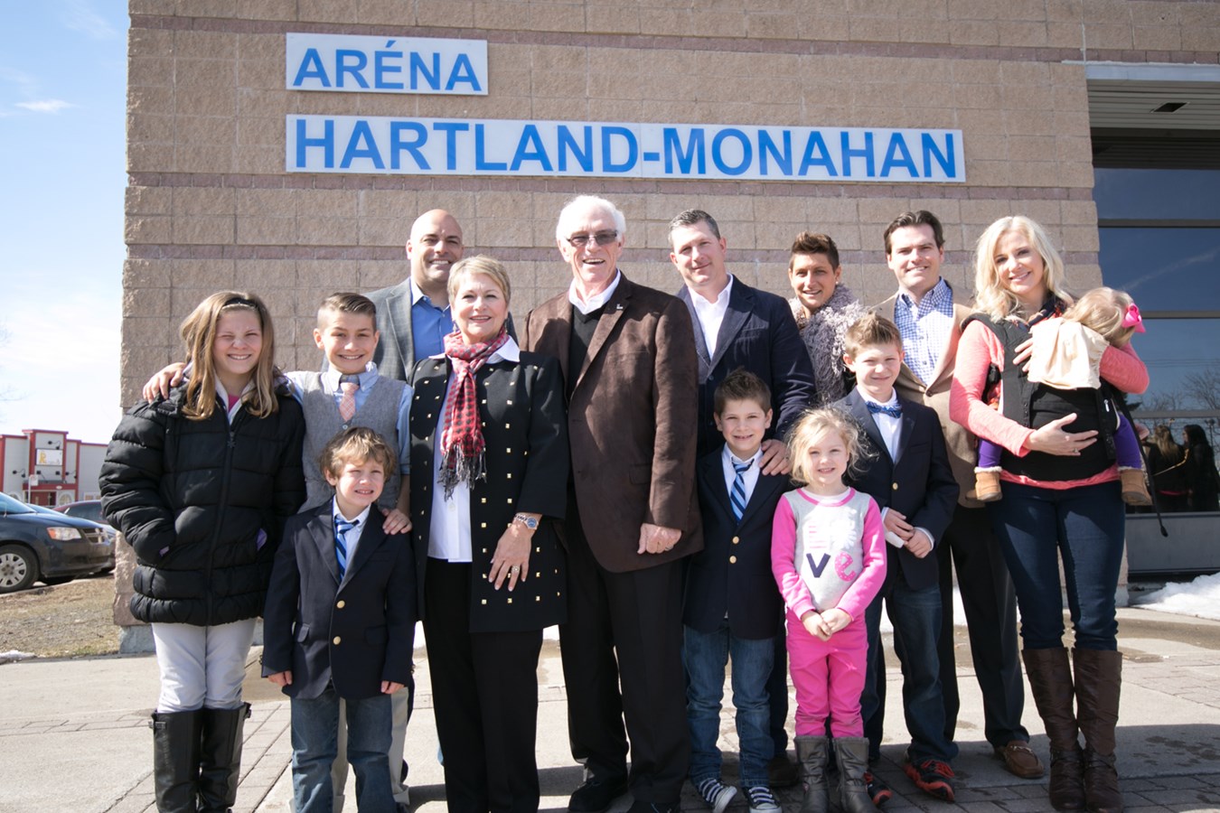 Hartland Monahan et sa famille posent devant l'aréna qui porte son nom.