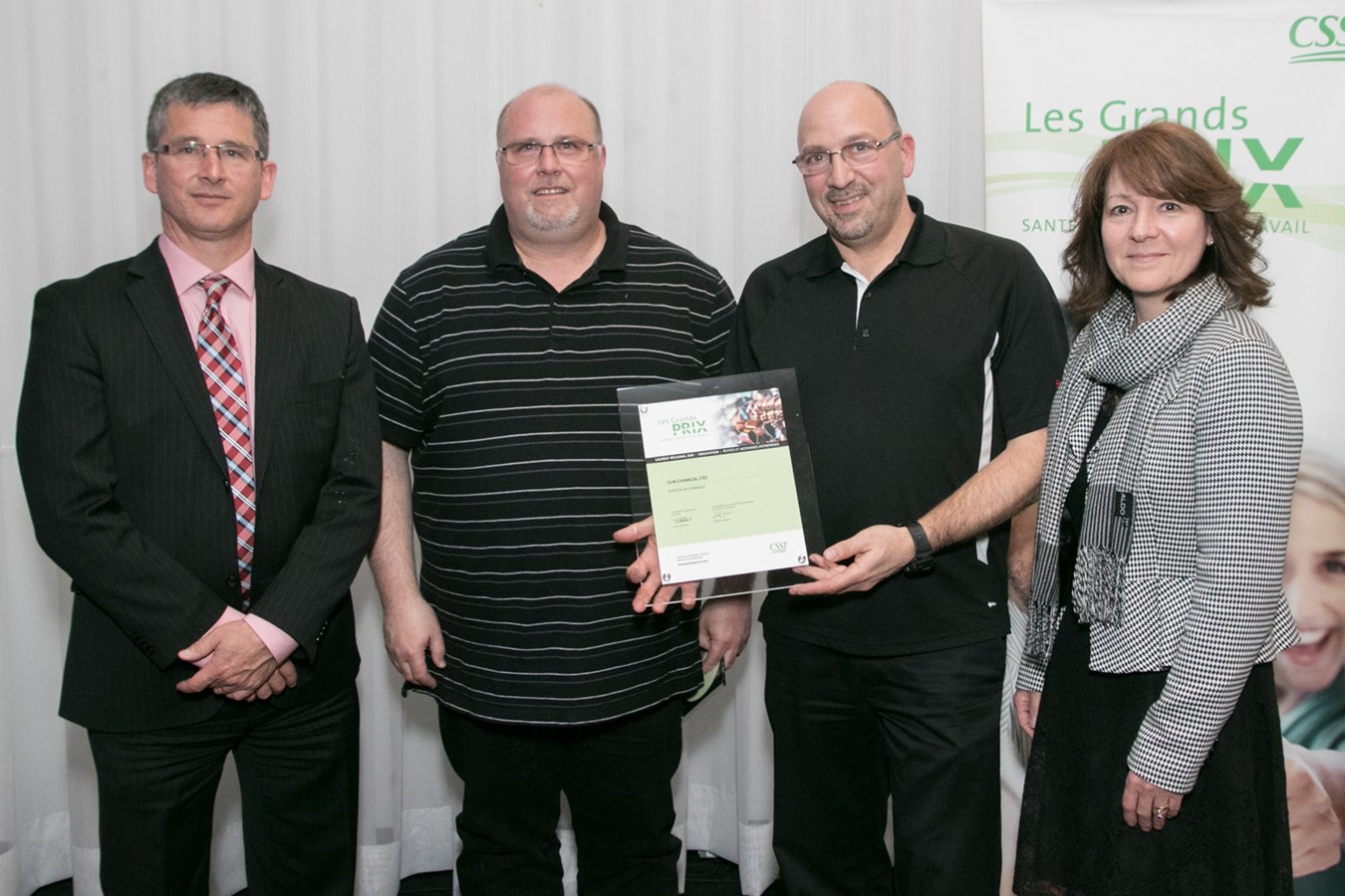 Sun Chemical ltée fût consacrée lauréate dans la catégorie Petites et moyennes entreprises. Sur la photo, les représentants de l'entreprise reçoivent leur prix des mains de M. Carl Gauthier, Vice-président aux finances de la CSST et de Madame Lucie Guindon, directrice régionale de Laval, CSST.
