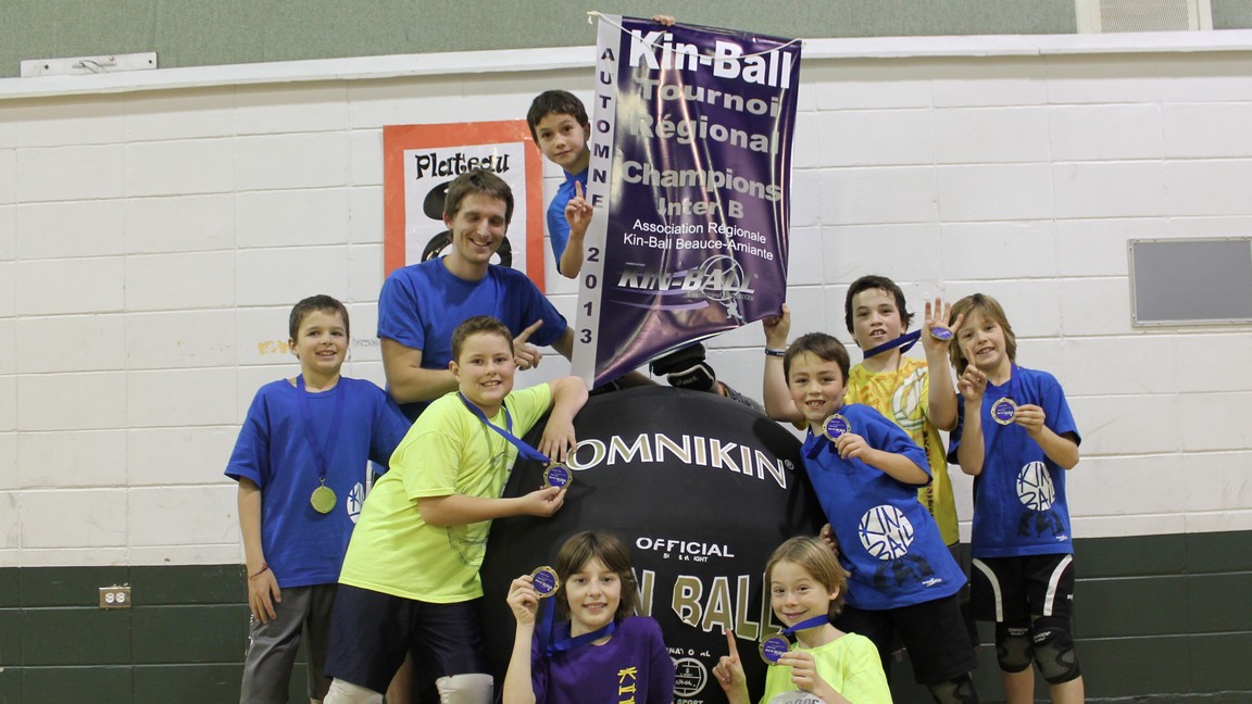 Les "Stars du Kin" pose fièrement avec leur bannière, symbole de leur victoire
