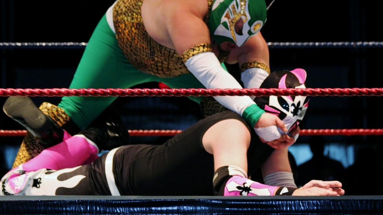 Deux "luchadors" se sont affrontés.  Mystica, en vert, et Knightman, en rose et noir.