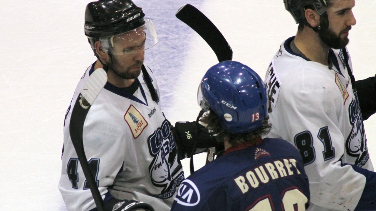 Le capitaine Kévin Cloutier au centre de la patinoire félicite un opposant.
