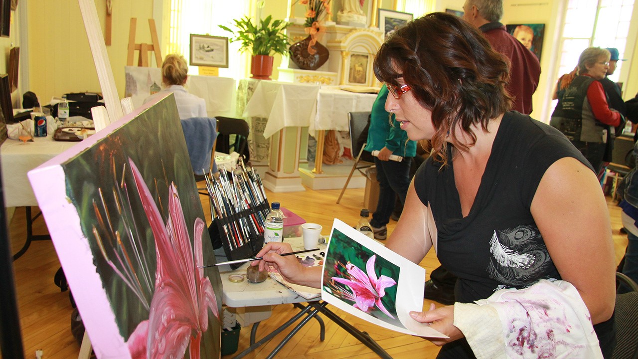 Kathy Cloutier reproduit une fleur sur une toile.